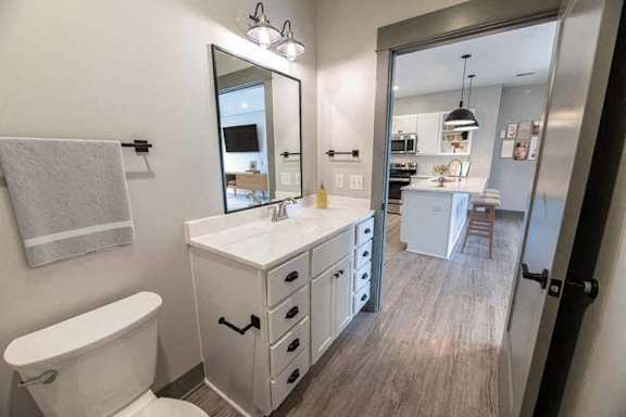 A bathroom with a white vanity and a white toilet.