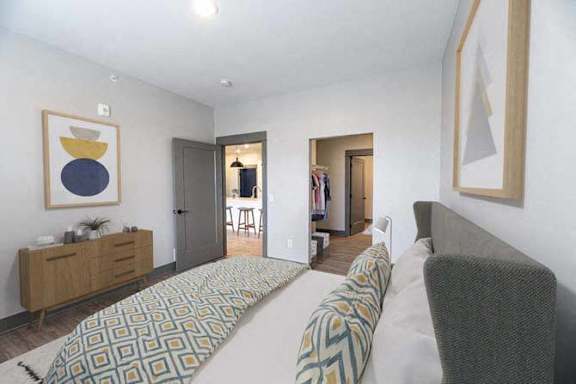 A living room with a couch, a chair, and a patterned blanket.