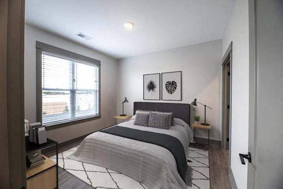 A bedroom with a large bed and two lamps.