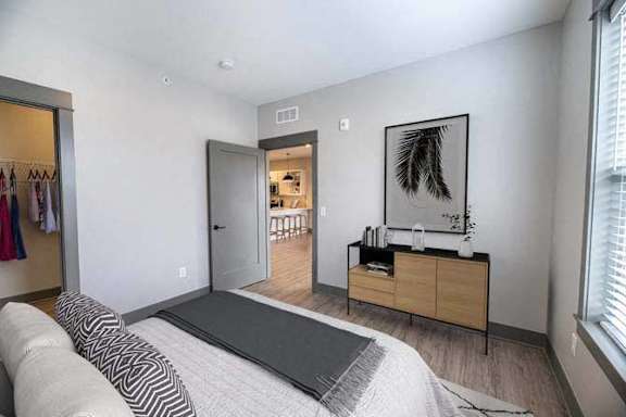 A bedroom with a bed, dresser, and wardrobe.