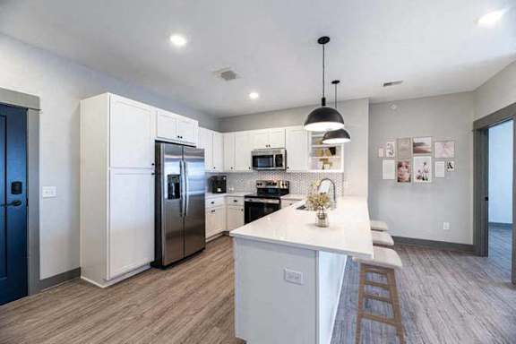 A modern kitchen with a center island and stainless steel appliances.