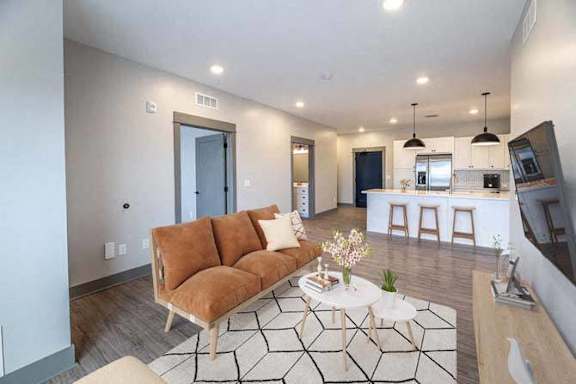 A living room with a brown couch and a white coffee table.
