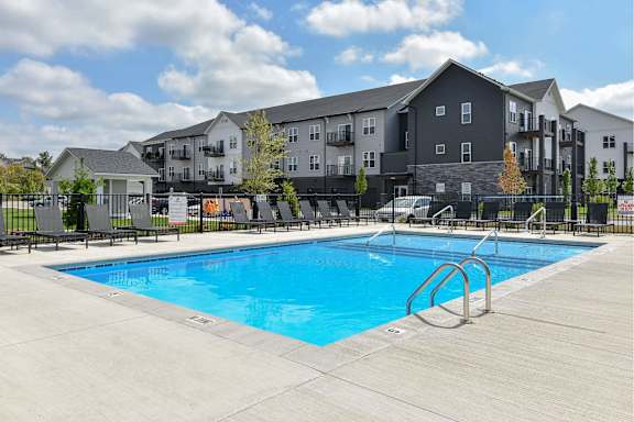 A swimming pool in front of apartment buildings.