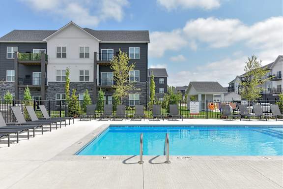 A large swimming pool in front of apartment buildings.
