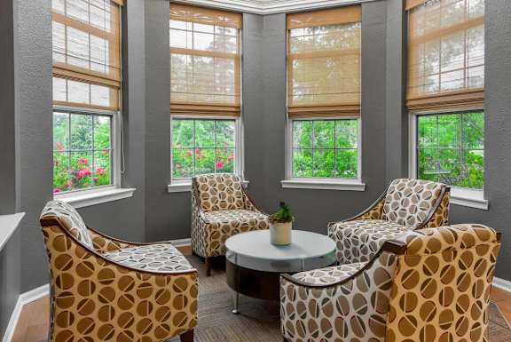 A living room with a table and three chairs.