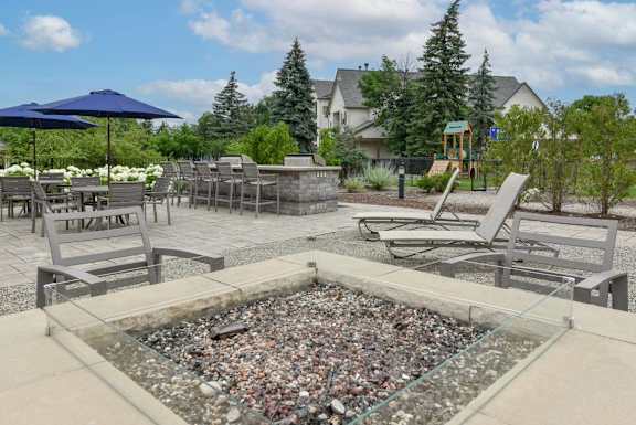 A glass table with a rock garden in the middle of a patio.