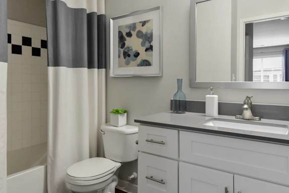 A bathroom with a toilet, sink, and a mirror.