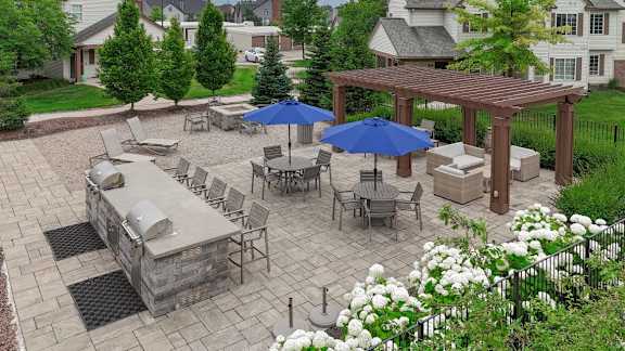 A patio with a table and chairs under a blue umbrella.