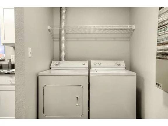 A white washing machine and dryer in a small laundry room.