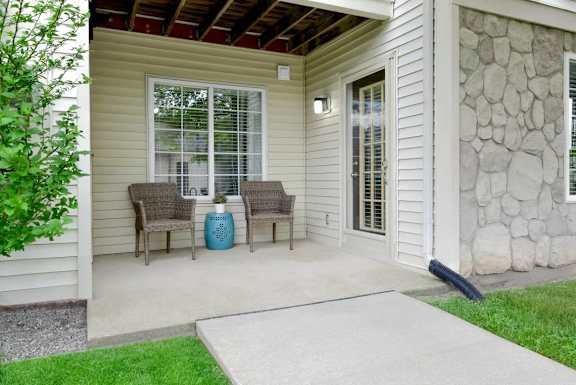 A patio with a table and chairs and a blue vase.
