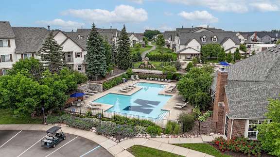 A swimming pool surrounded by houses and trees.