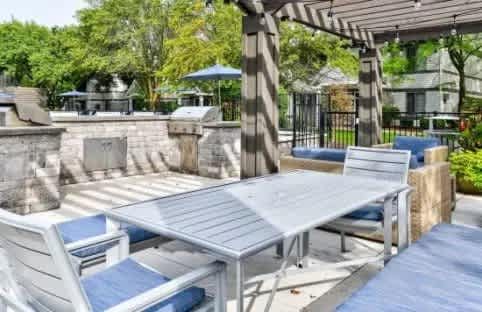 A patio with a table and chairs under a pergola.