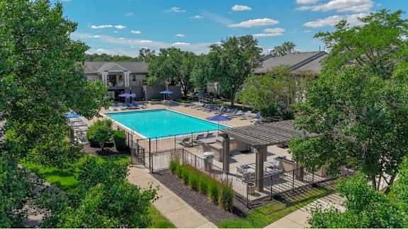 A swimming pool surrounded by a fence and trees.