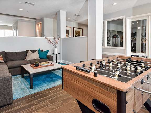 A foosball table sits in the middle of a living room.