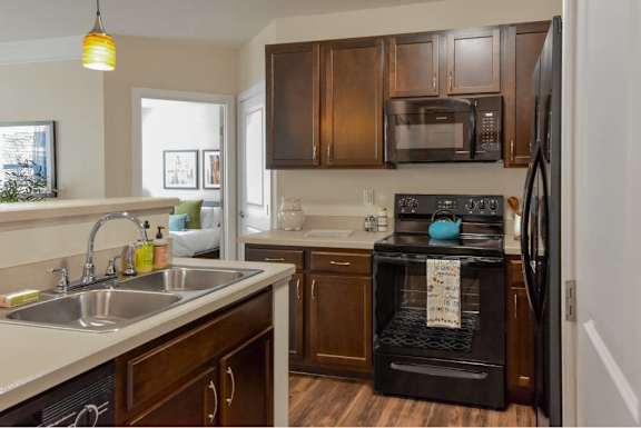 A kitchen with brown cabinets and a black oven.