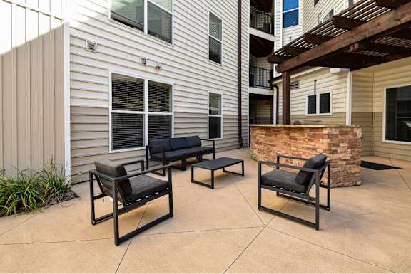 A patio with two black chairs and a table.