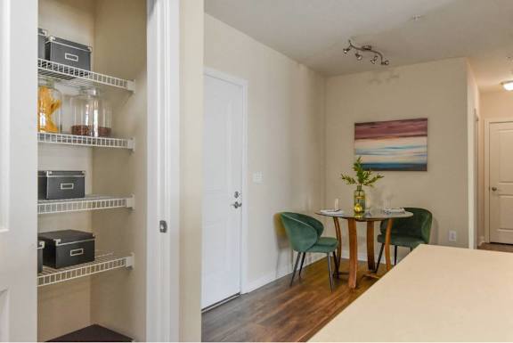 A room with a dining table and chairs.