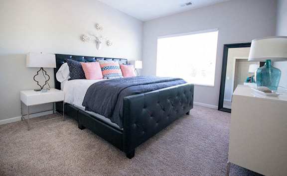 A bedroom with a large bed and a nightstand.