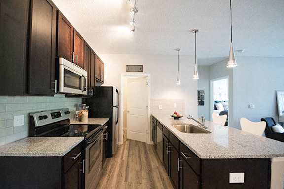 A kitchen with black cabinets and a white counter top.