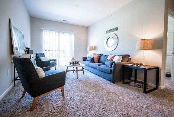 A living room with a black chair and a black couch.