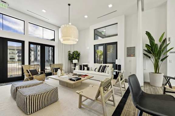 A living room with a large window and a view of a building outside.
