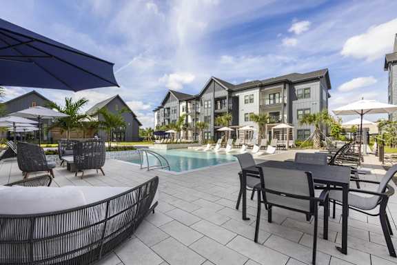 A swimming pool with tables at new luxury apartments in Tampa.