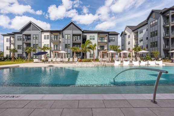 Swimming pool with Azalea Luxury Apartments apartment building in the background.