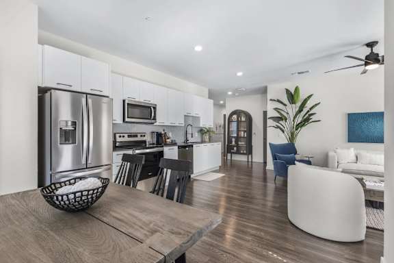 A modern kitchen with a refrigerator, microwave, and oven.