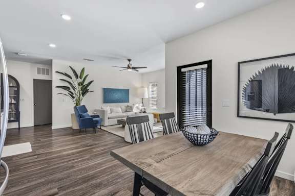 A modern dining room with a wooden table and chairs.