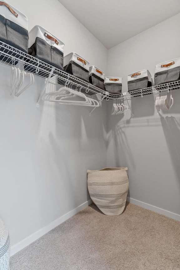 A laundry room with a white wall and a basket on the floor.