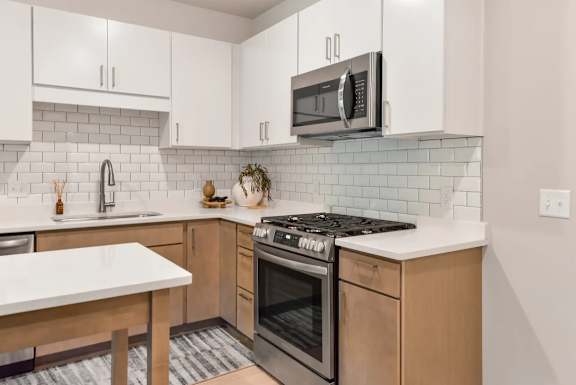 A kitchen with a white countertop and a black stove top oven.