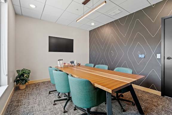 A conference room with a long table and chairs.
