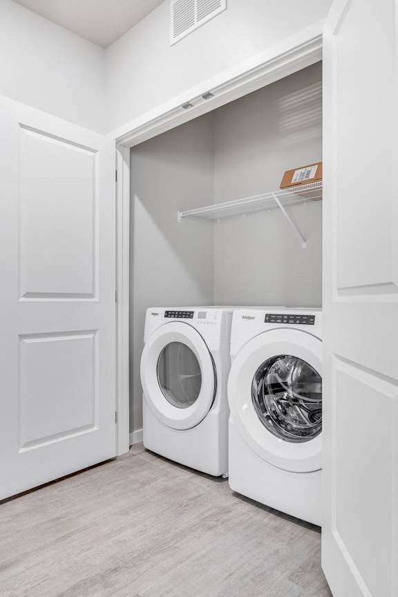 A white laundry room with two washing machines.