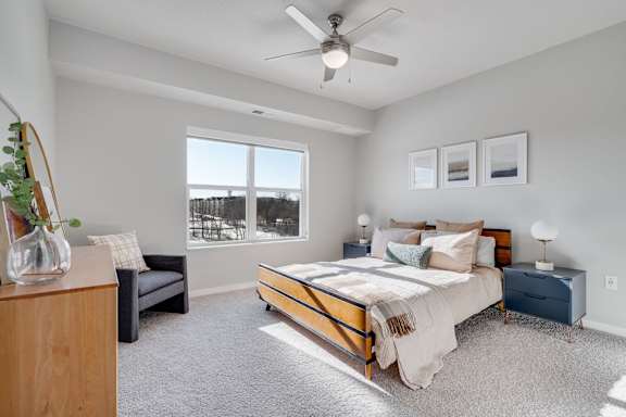 A bedroom with a bed, nightstands, and a window.
