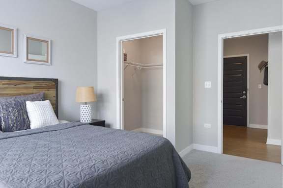 A bedroom with a bed, lamp, and two pictures on the wall.