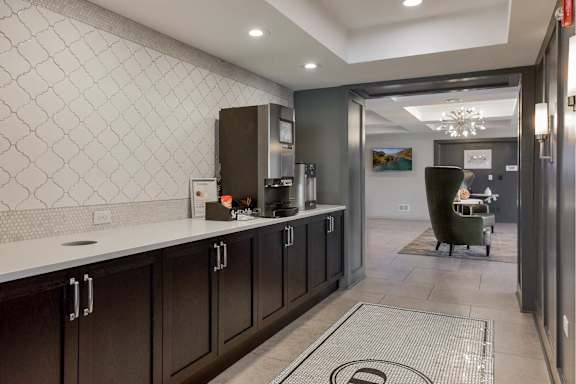A kitchen with dark wood cabinets and a white countertop.