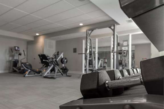 A black dumbbell is on a bench in a gym.