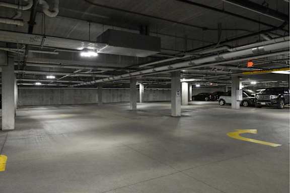 A parking garage with a yellow arrow on the ground.