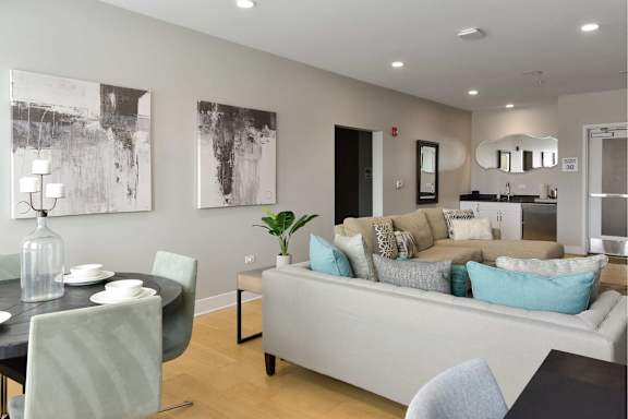A modern living room with a black dining table and a grey sofa.