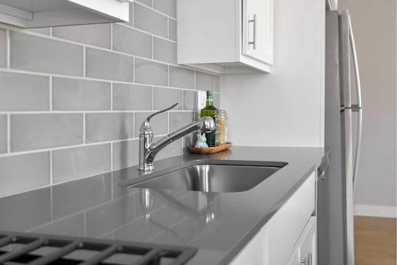 A kitchen with a sink and a refrigerator.