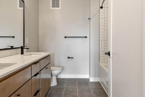 A bathroom with a toilet, sink, and a door.