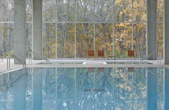 An indoor pool with glass windows at Optima Old Orchard Woods luxury apartments in North Chicago