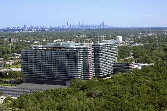 A large building with a lot of windows is surrounded by trees.
