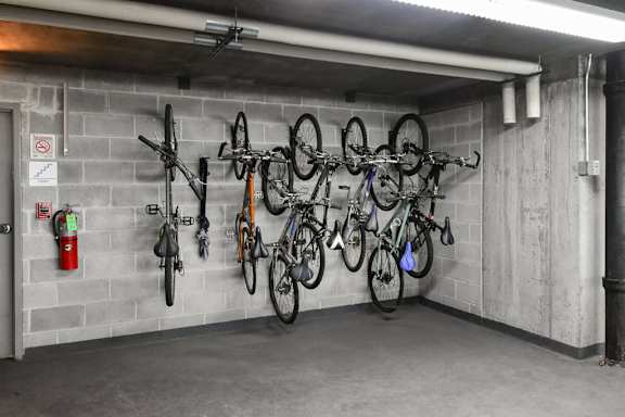 A bike rack with several bicycles hanging on it.