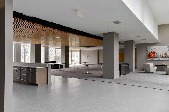 Large open interior living space with kitchen area and seating at Optima Old Orchard Woods luxury apartments in Skokie, IL
