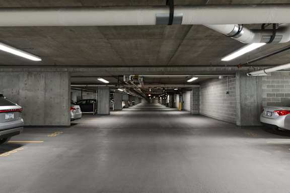 A long, narrow parking garage with cars parked on both sides.