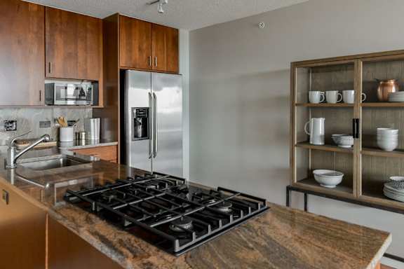 A modern kitchen with a stove top and a refrigerator.