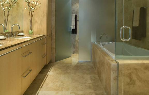 A bathroom with a glass shower stall and a sink with a mirror.