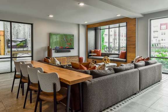 A modern living room with a long wooden table and chairs.