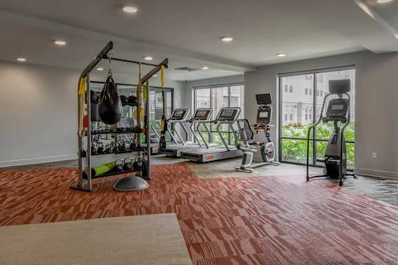 A gym with a red floor and various exercise equipment.